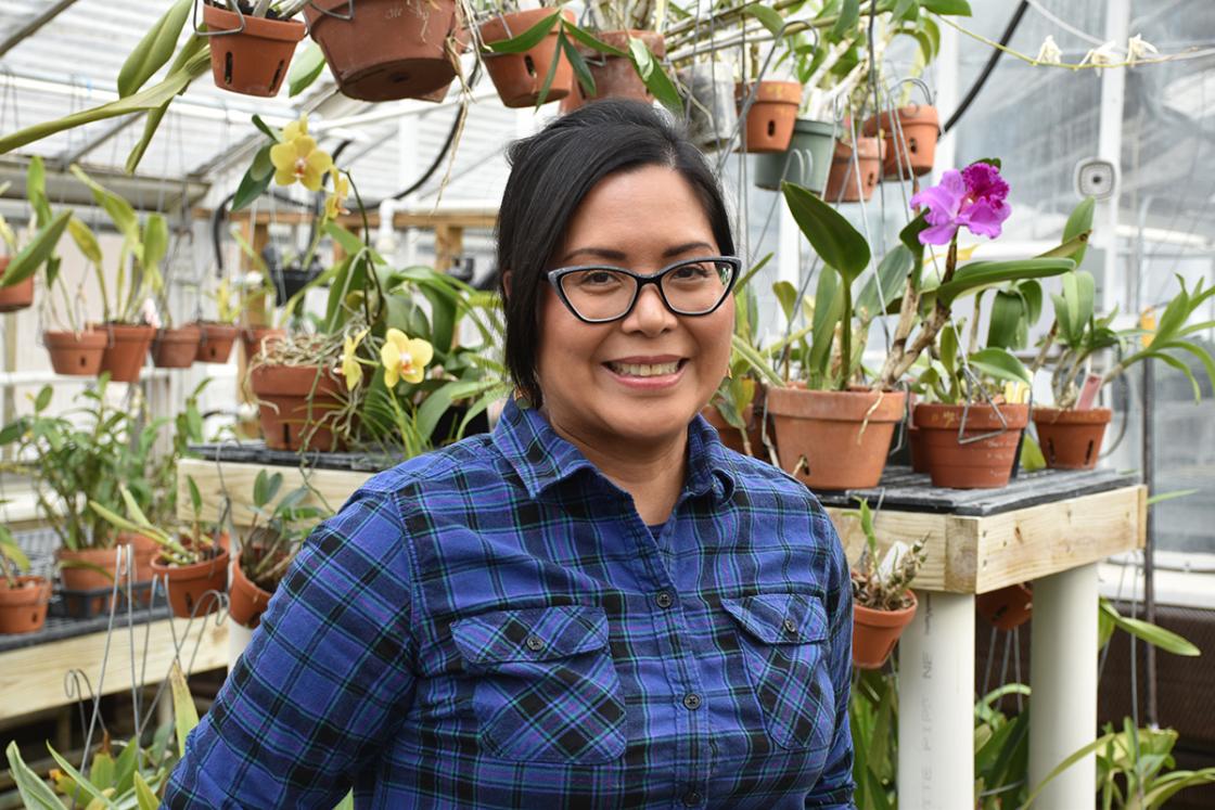 Photograph of a smiling volunteer in the Conservatory Greenhouse at Cranbrook House & Gardens.