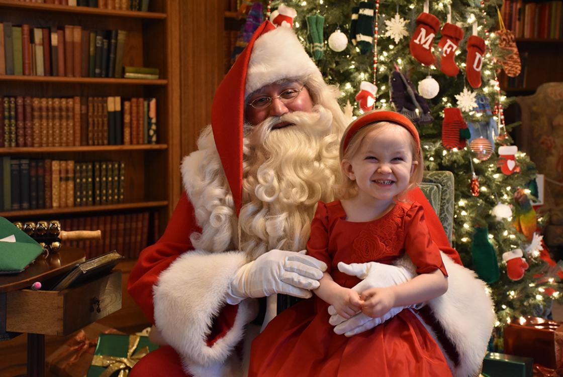 Photograph of a girl visiting with Santa during Holiday Splendor at Cranbrook House, December 2018.
