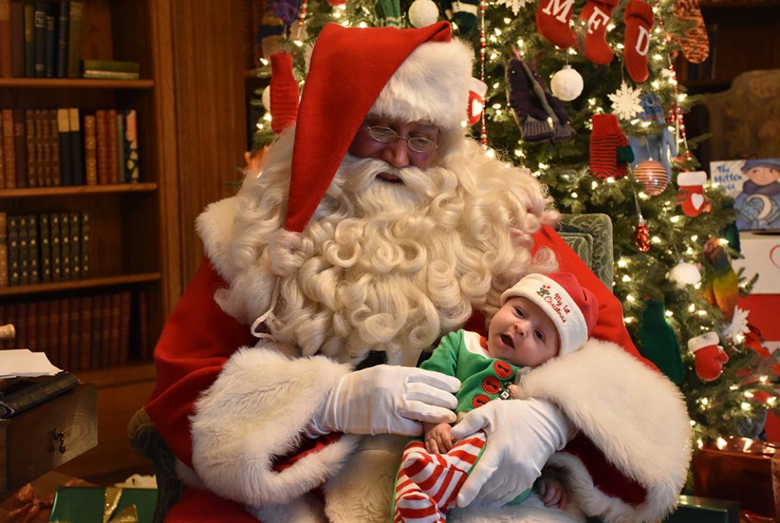 Photograph of Santa with a baby during Holiday Splendor at Cranbrook House, December 2018.