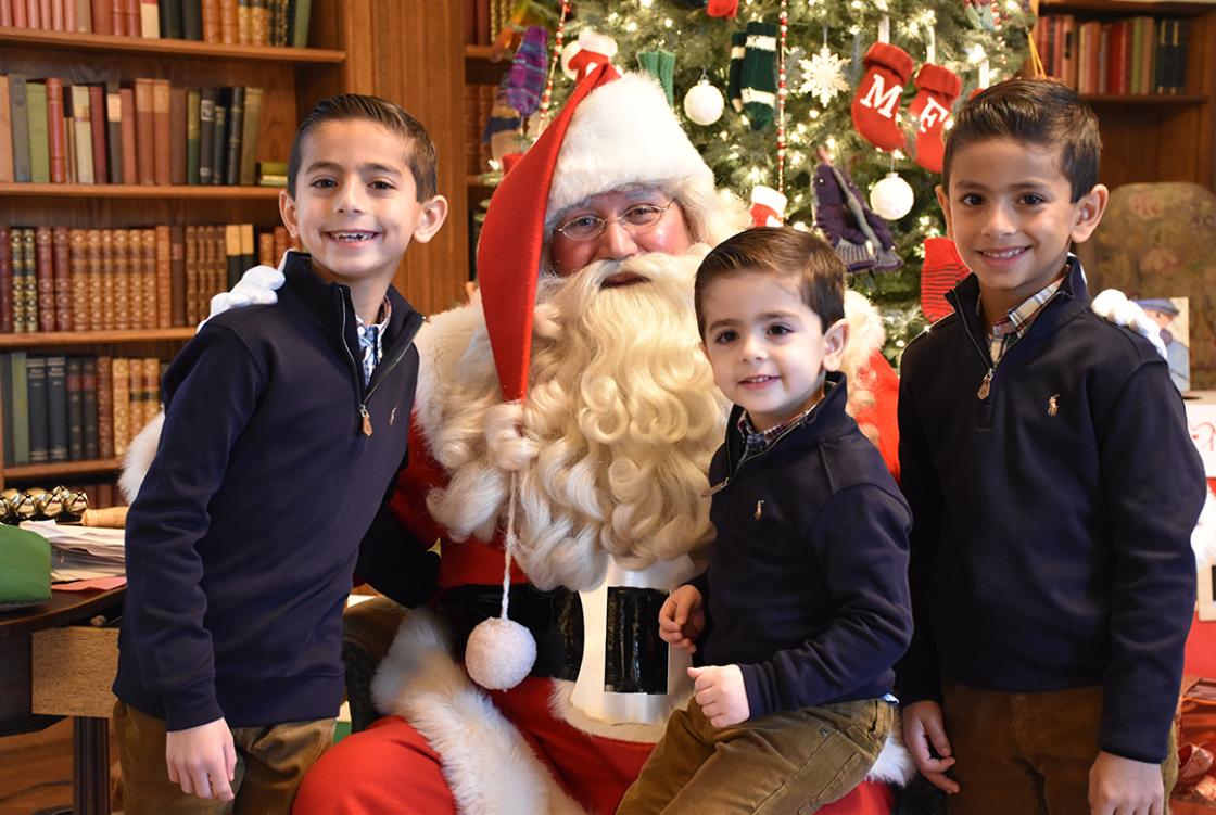 Photograph of three boys with Santa at Cranbrook House during Holiday Splendor, December 2018.