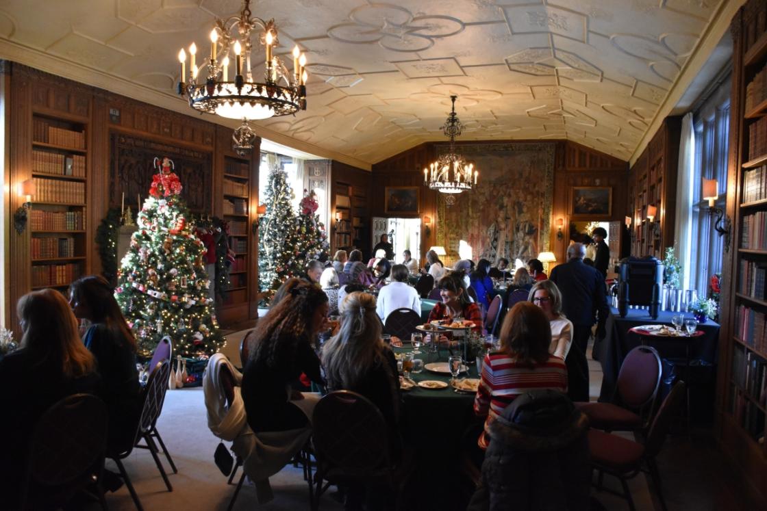 Photo of visitors in the Cranbrook House Library during a holiday tea.
